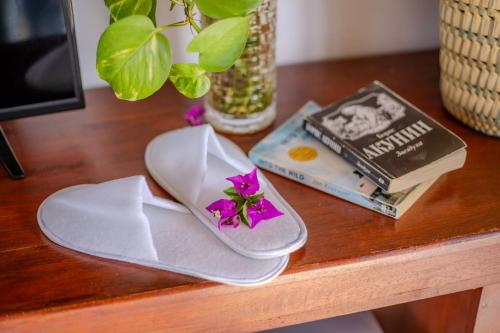 einen Tisch mit einem Paar Sandalen und einem Buch in der Unterkunft The Waves Unawatuna in Unawatuna