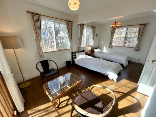Sala de estar con 2 camas y mesa en 八ヶ岳エンゼル #Ag1, en Hokuto