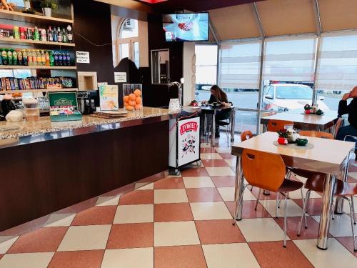 a restaurant with a counter and tables and people sitting at tables at Motel Górno in Górno