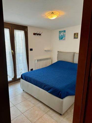 a bedroom with a bed with a blue comforter at VIDI HOME in Vidiciatico