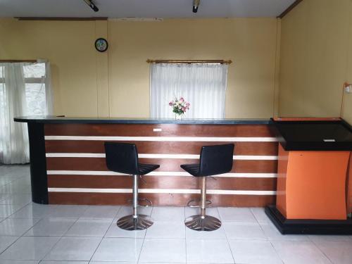 a bar in a room with two chairs and a counter at Bromo Holiday Guest House in Ngadisari