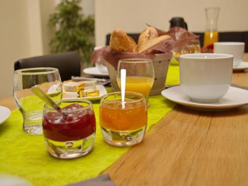 una mesa con copas de bebidas y un tazón de pan en Ô Délices de la Monnerie, en Bourgnac