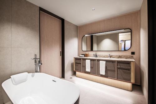 uma casa de banho com um lavatório branco e um espelho. em Intercity Shanghai Hongqiao Airport em Xangai