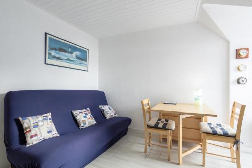 un salon avec un canapé bleu et une table dans l'établissement Appartement Guillaume vue mer, à Trégunc