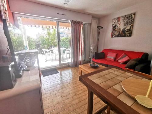 un salon avec un canapé rouge et une table dans l'établissement 175 Beverley Hills D64 2 pièces cabine, au Cap d'Agde
