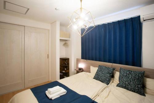 a bedroom with a bed with two towels on it at エメラルド色に輝く希望ヶ丘ビーチまで徒歩圏内！リゾート地恩納村のお洒落な3LDK一軒家貸し切り！ in Inbu