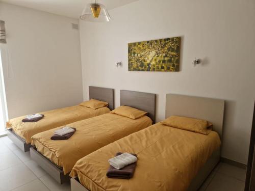 two beds sitting next to each other in a room at Modern 3BR Apartment in Swieqi in Is-Swieqi