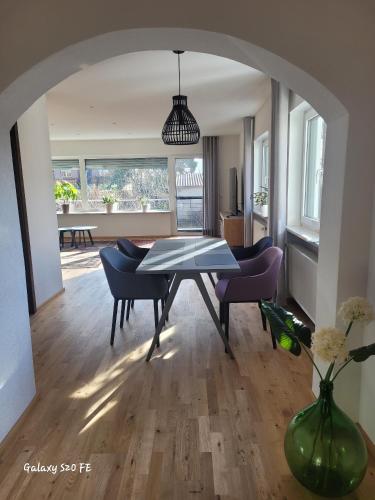 a dining room with a table and chairs and a room with a table at Modernes Ferienappartement An der Steige in Wilhermsdorf