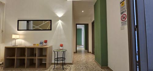 einen Flur mit grünen und weißen Wänden und einem Hocker in der Unterkunft Palermo Politeama rooms in Palermo