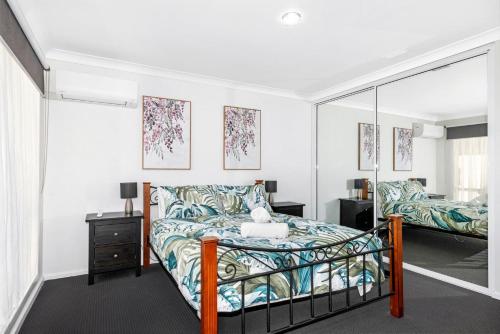 een slaapkamer met een bed en een spiegel bij Broadwater Bay Villa in Broadwater
