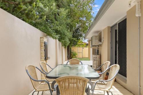 a patio with a glass table and chairs at Broadwater Bay Villa in Broadwater