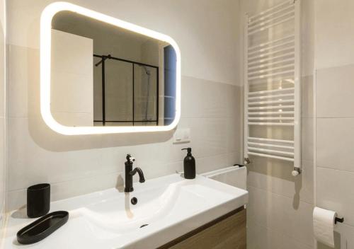 a white bathroom with a sink and a mirror at Apartamento en Colón - Logroño in Logroño