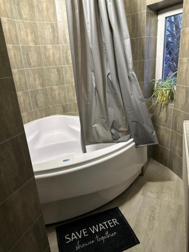 a bathroom with a bath tub and a shower curtain at Nautilus in Uzhhorod