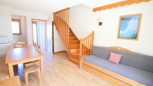 - un salon avec un canapé, une table et un escalier dans l'établissement Résidence Parc Aux Etoiles - CH17PAE - CHALET DUPLEX 2 CHAMBRE, TERRASSE ET BALCON MAE-2114, à Narreyroux