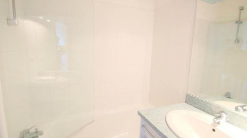 Un baño blanco con lavabo y bañera. en Résidence Parc Aux Etoiles - CH17PAE - CHALET DUPLEX 2 CHAMBRE, TERRASSE ET BALCON MAE-2114, en Narreyroux
