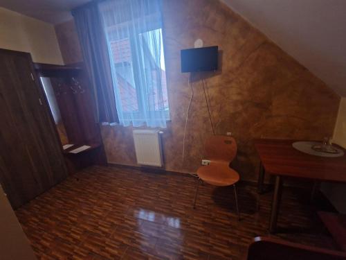 um pequeno quarto com uma mesa e uma cadeira em Motel Górno em Górno