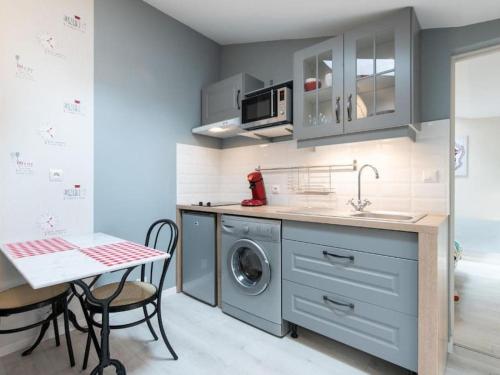 cocina con lavadora y mesa en Le Paris Eiffel - Appartement Cosy en plein centre, en Bourgoin