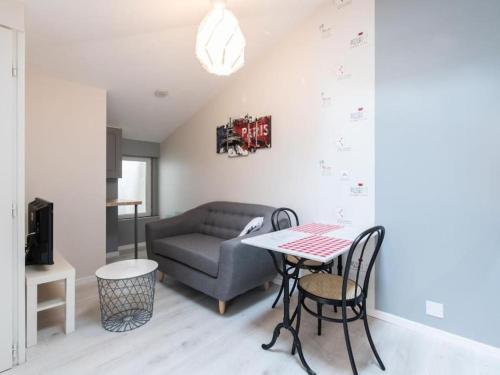 sala de estar con sofá y mesa en Le Paris Eiffel - Appartement Cosy en plein centre, en Bourgoin