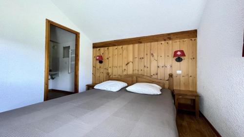 - une chambre avec un lit et un mur en bois dans l'établissement Résidence Dame Blanche - DBAC25 - APPT 3 CHAMBRES - BALCON - 8 PERSONNES - Secteur 1800 MAE-8044, à Narreyroux