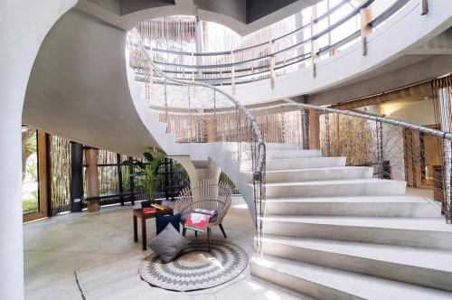 a spiral staircase in a house with a chair at Spin Designer Hostel - El Nido in El Nido