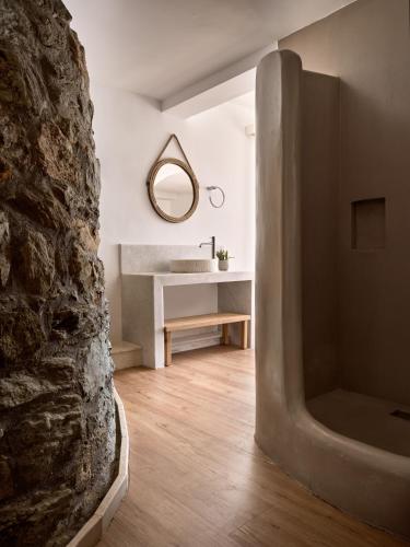 a bathroom with a sink and a stone wall at Seaside A Lifestyle Resort - Adults Only in Agia Pelagia