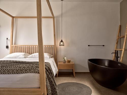 a bedroom with a black tub next to a bed at Seaside A Lifestyle Resort - Adults Only in Agia Pelagia