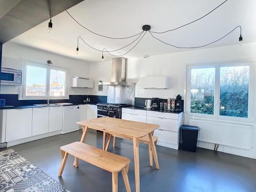 une cuisine avec une table en bois et deux bancs dans l'établissement Maison de vacances en famille, à Agon-Coutainville
