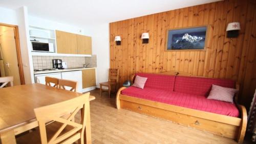 un salon avec un canapé rouge et une cuisine dans l'établissement Résidence Parc Aux Etoiles - C101PAE - APPARTEMENT 2 CHAMBRES AVEC TERRASSE MAE-8744, à Narreyroux