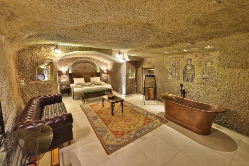 Zimmer mit einem Bett und einem Sofa in einer Höhle in der Unterkunft Divan Cave House in Goreme