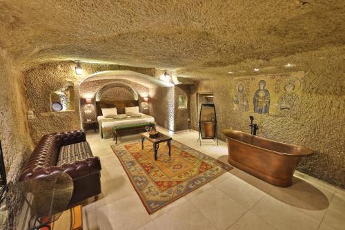 ギョレメにあるディヴァン ケーブ ハウスの洞窟内のベッドとソファ付きの部屋