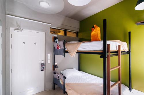 a bunk bed room with two bunk beds and a green wall at Spin Designer Hostel - El Nido in El Nido
