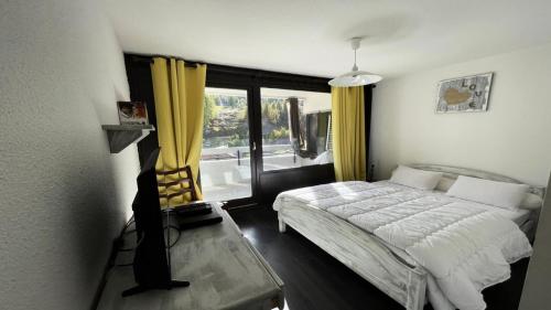 une chambre avec un lit et une grande fenêtre dans l'établissement Résidence Pendine 1 - P907 - Appt T2/Coin montagne - 6 personnes - Centre st 144, à Les Prés