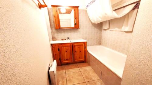 a bathroom with a tub and a sink and a mirror at Résidence Les Queyrettes - Agréable Appartement Traversant 6 Personnes avec Balcon MAE-4354 in Puy-Saint-Vincent