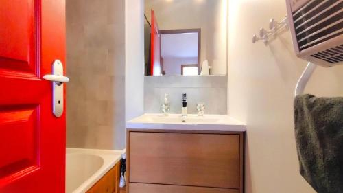 ein Bad mit einem Waschbecken und einem Spiegel in der Unterkunft Résidence Le Palatin - Appartements pour 6 Personnes 344 in Pelvoux