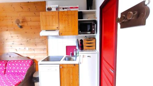 eine kleine Küche mit Kühlschrank und Spüle in der Unterkunft Résidence Le Palatin - Appartements pour 6 Personnes 344 in Pelvoux