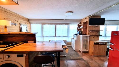 a kitchen with a wooden table and a refrigerator at Résidence Valgardena - Appartements pour 4 Personnes 471 in Puy-Saint-Vincent