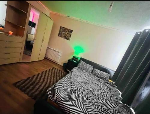 a bedroom with a bed and a green lamp at House in Peterborough
