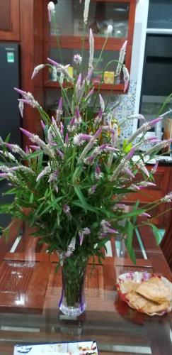 a vase filled with purple flowers on a table at Garden House Côn Đảo in Con Dao