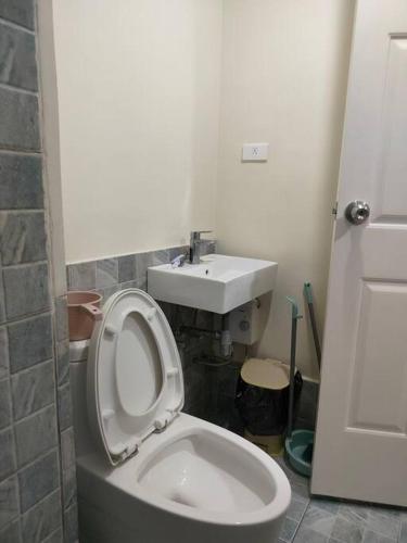 a bathroom with a white toilet and a sink at feliz studio condo at banilad in Cebu City