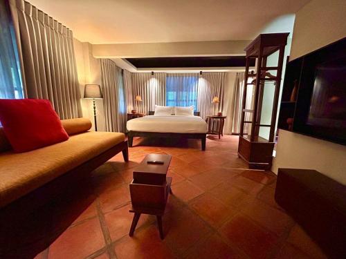 The Henry Resort Boracay في بوراكاي: غرفه فندقيه بسرير واريكه