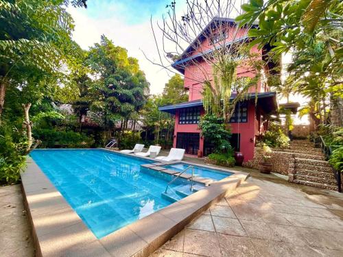 a swimming pool in front of a house at The Henry Resort Boracay in Boracay