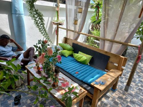 a man sitting on a couch in a room at Open Air Café & Apartments in Port Louis