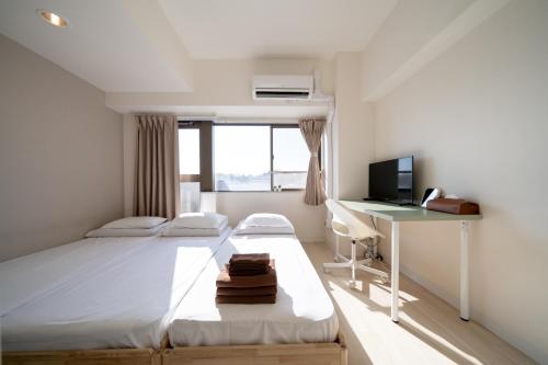 a bedroom with a bed and a desk and a computer at Nishinippori Guest House in Tokyo