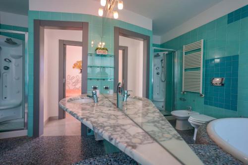 a bathroom with two sinks and a tub and a toilet at Villa Rosanna in Capoterra