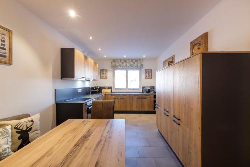 a kitchen with a wooden table and a dining room at Ferienwohnung Gschwandtnerhof 