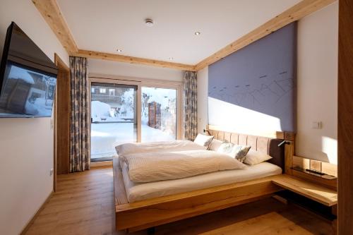 1 dormitorio con cama y ventana grande en Ferienwohnung Gschwandtnerhof, 