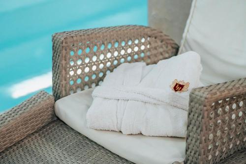 a stack of towels sitting on a wicker chair at Tbilisi Laerton Hotel in Tbilisi City