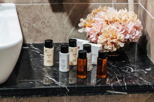 a group of four bottles of essential oils on a bathroom counter at Tbilisi Laerton Hotel in Tbilisi City