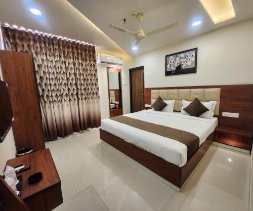 a hotel room with a bed and a television at HOTEL 4ReN in Bhavnagar