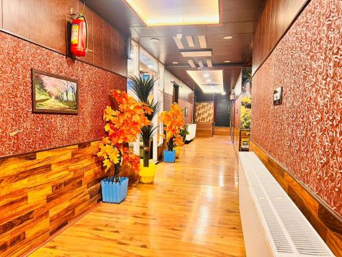 a hallway with vases of flowers in a building at Pine View Resort in Gulmarg